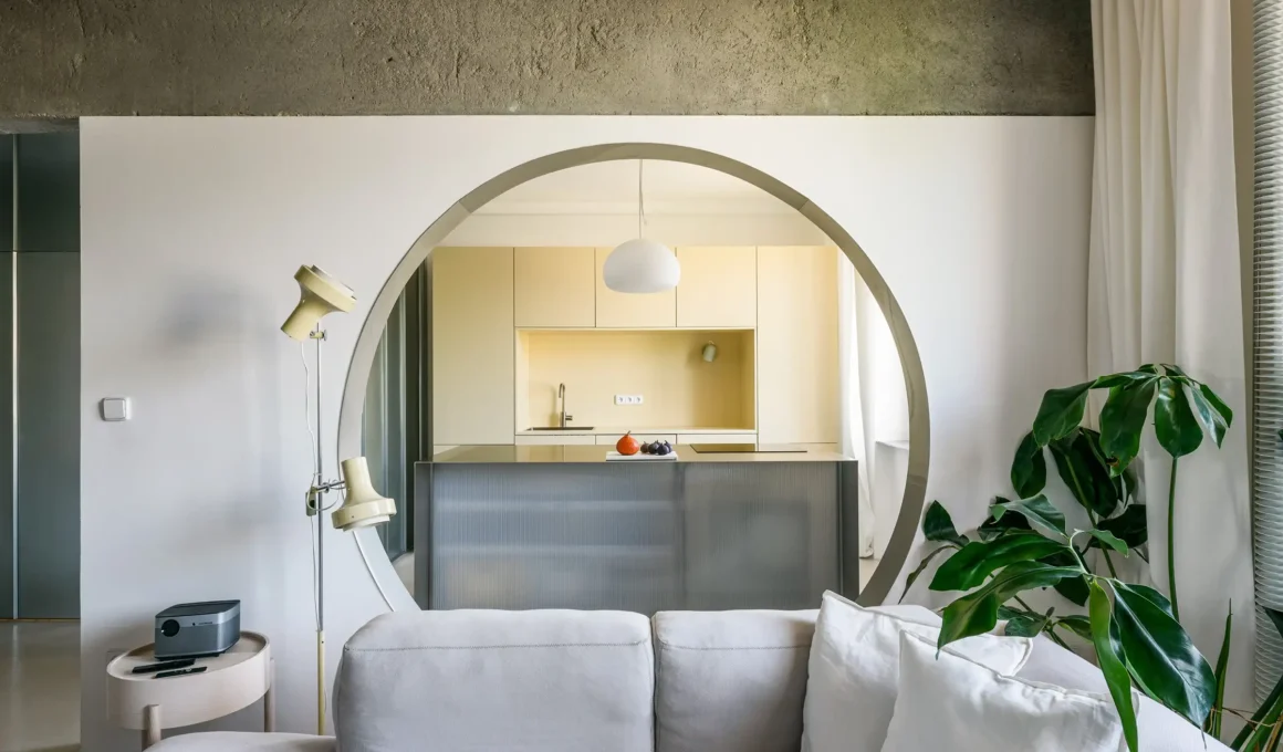 Kitchen in IO Apartment Bratislava: Stainless steel bar with recycled ceramic tiles under circular aperture, 1950s renovation by Alan Prekop
