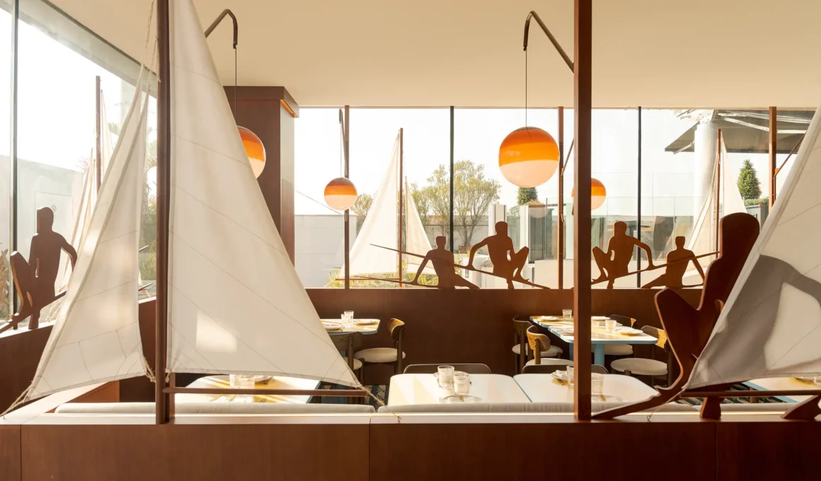 El Mar Lisbon maritime restaurant interior by Cateto Cateto: wooden sailboat structure, Portuguese azulejos tiles, Marset Dipping Lights at sunset