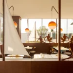 El Mar Lisbon maritime restaurant interior by Cateto Cateto: wooden sailboat structure, Portuguese azulejos tiles, Marset Dipping Lights at sunset