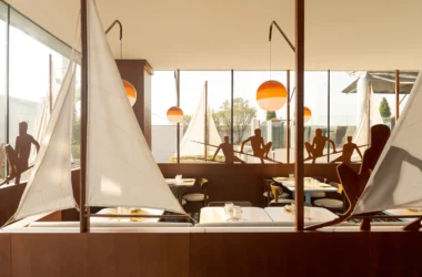 El Mar Lisbon maritime restaurant interior by Cateto Cateto: wooden sailboat structure, Portuguese azulejos tiles, Marset Dipping Lights at sunset