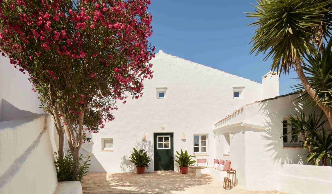 Traditional Menorcan house white limestone facade with wooden persianas shutters