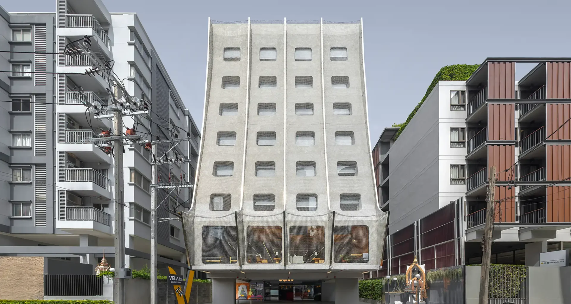 Vela be Siam Hotel Bangkok striking facade: ASWA-designed boutique hotel in Siam Square blending traditional Thai Pun-Lom woodwork with modern stainless steel chain links.