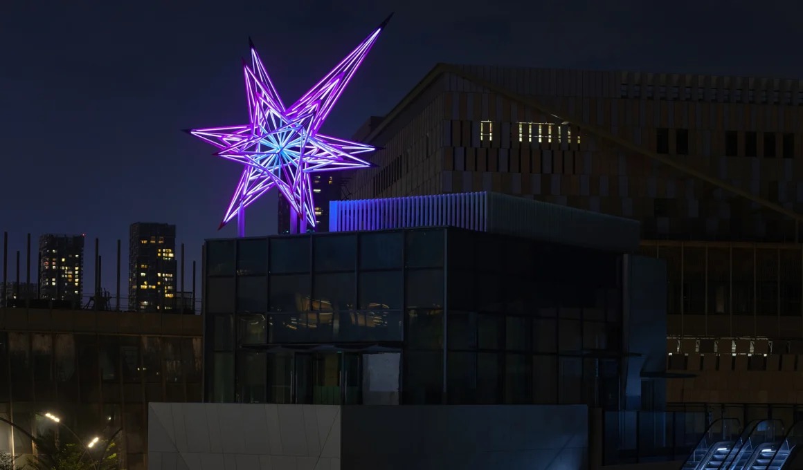 Jun Ong OURA light sculpture, a glowing comet tail installation at Prince Bay Shenzhen, made of stainless steel tubes and LED lights against ocean villas.