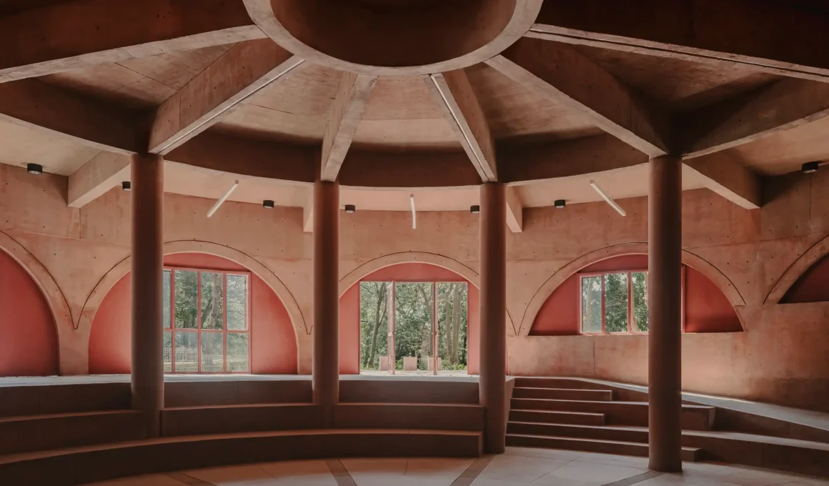 Circular multipurpose hall interior at UH INFONAVIT Santa Fe park by AMASA Estudio in Mexico City, showing radial concrete columns and beams.