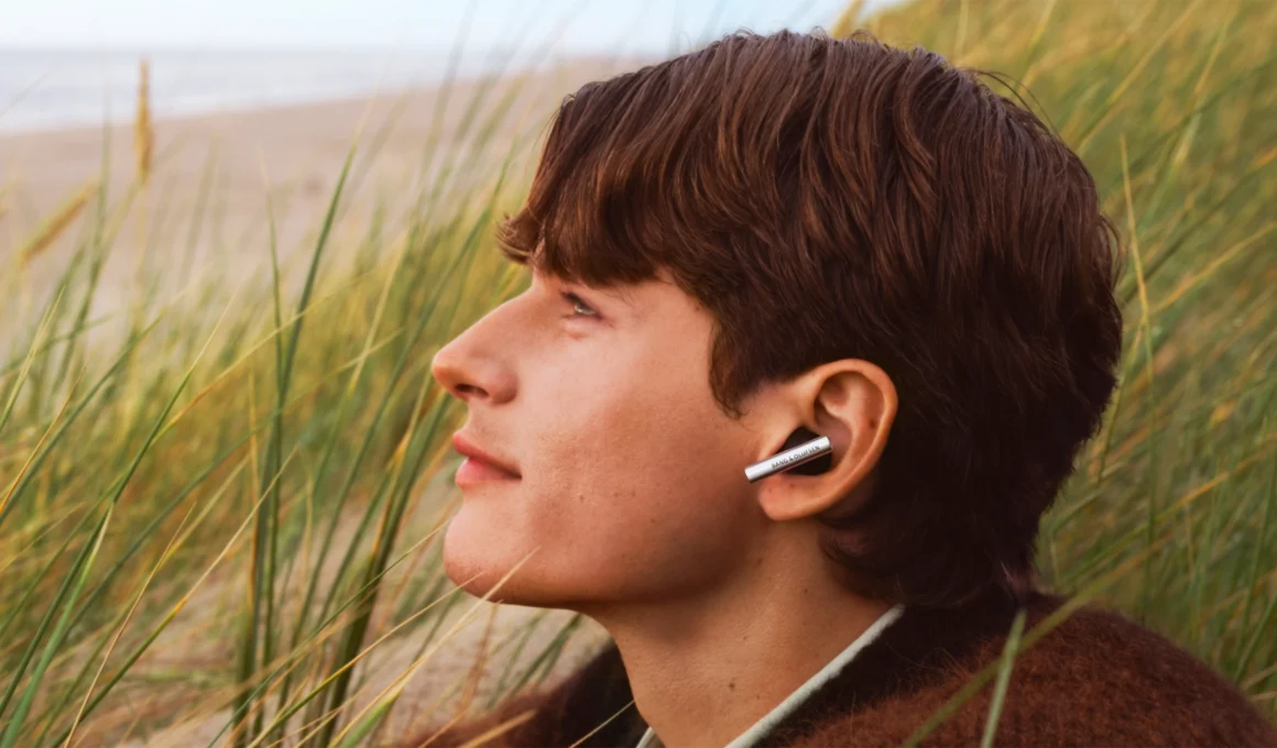 Bang & Olufsen Beo Grace wireless earbuds in open aluminium charging case, showcasing sculptural jewellery-inspired design and polished metal craftsmanship.