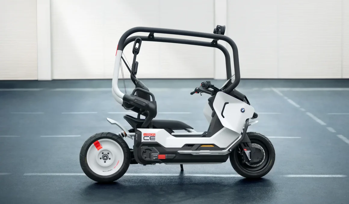 BMW Motorrad Vision CE electric motorcycle vision vehicle in matt white with black safety cage, showcasing its helmet-free self-balancing design for urban mobility.