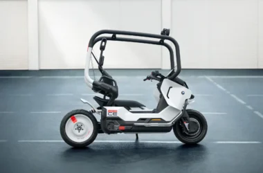 BMW Motorrad Vision CE electric motorcycle vision vehicle in matt white with black safety cage, showcasing its helmet-free self-balancing design for urban mobility.