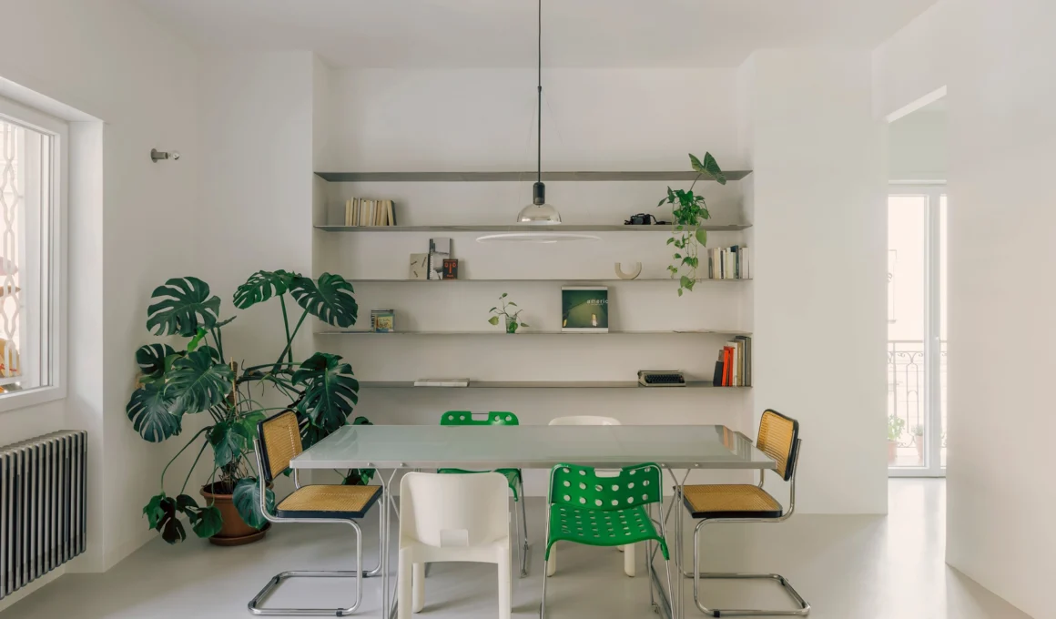 PAROS architettura's dining room in Casa Tirreno Rome apartment renovation, featuring a luminous glass-brick wall and organic masonry bench.