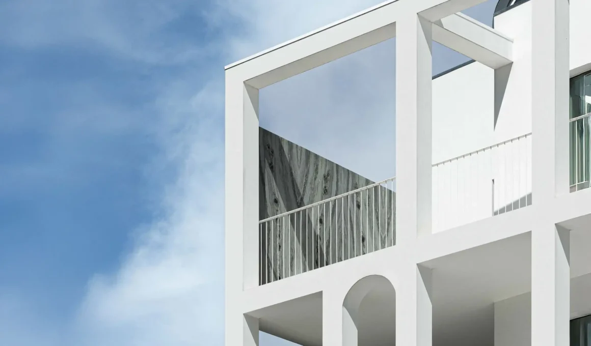 Adaptive reuse architecture by MASSLAB: restored facade of Vila Catarina Apartments, a former courthouse in Porto with original stonework and blue ceramic tiles.