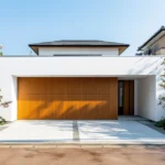 Professional garage door technician installing a modern smart garage door opener with a drill