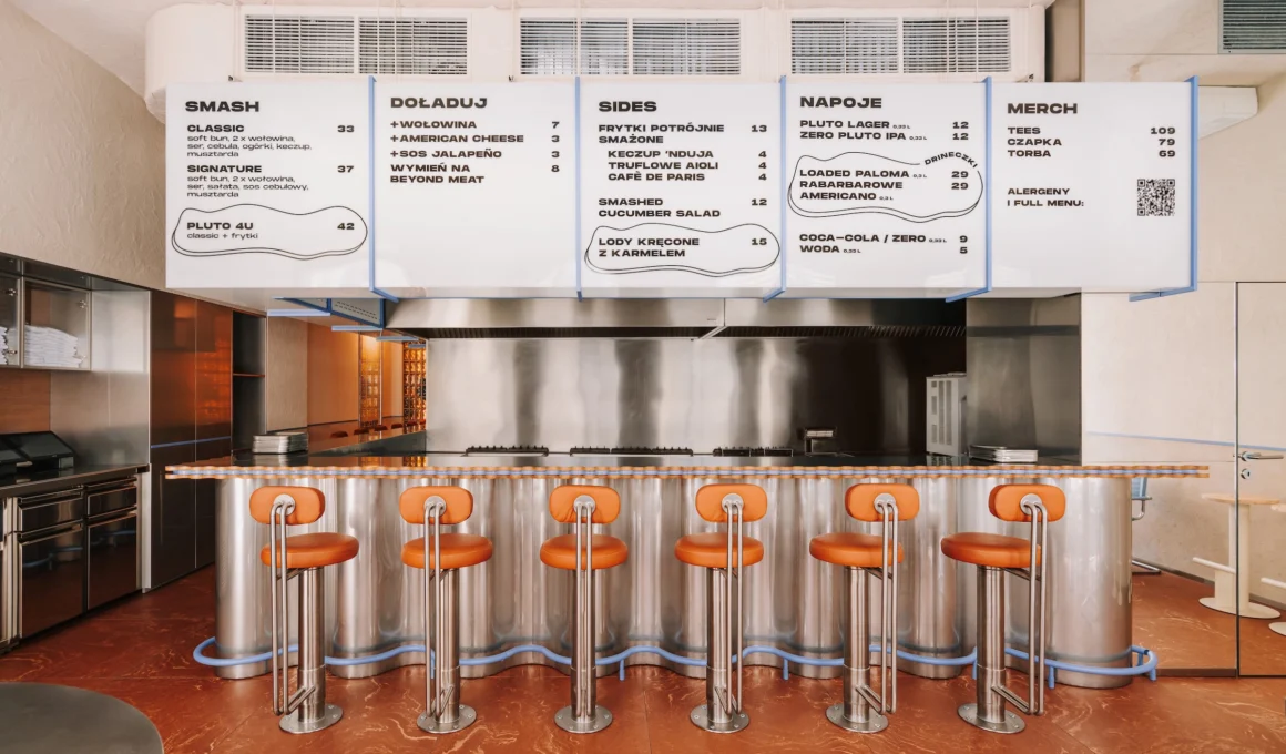 Minimalist interior of PLUTO smash burger restaurant in Wrocław designed by Znamy Się, featuring a caramel-toned bar, leather stools, and the signature pulsing blue line.