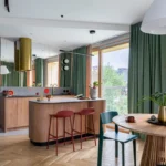Renter-friendly living room with a modern grey armchair, lush indoor plants in design pots, and removable decor on a neutral wall.
