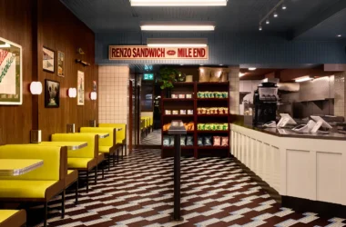 Renzo sandwich shop Montreal interior design by MRDK featuring custom mosaic tile floor and soft yellow upholstered booths.