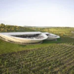Aerial view of the contemporary Sauska Tokaj winery by BORD Architectural Studio, a floating concrete and glass structure with sunset terraces overlooking the vineyards of the UNESCO Tokaj wine region, Hungary.