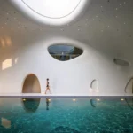 Wutopia Lab's The Rock Cloud Center cantilevered pebble-shaped mountain hotel with outdoor hot spring pools and view of Great Wall in Zunhua, China.