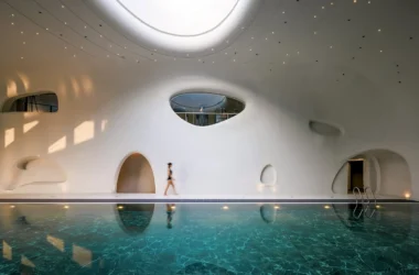 Wutopia Lab's The Rock Cloud Center cantilevered pebble-shaped mountain hotel with outdoor hot spring pools and view of Great Wall in Zunhua, China.