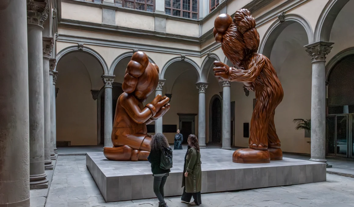 KAWS The Message six-meter wooden sculpture of COMPANION and BFF in Palazzo Strozzi Florence Renaissance courtyard.