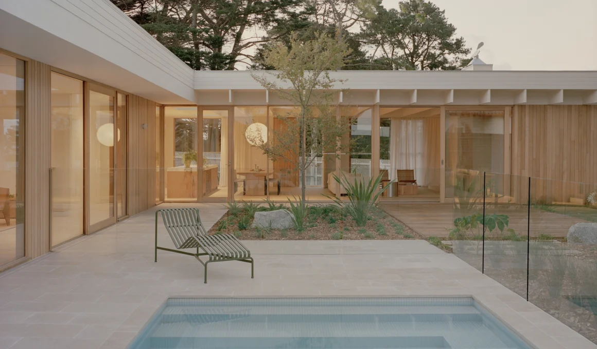 L-shaped Mount Martha House timber architecture by Victoria Merrett Architects overlooking the integrated coastal swimming pool and deck.