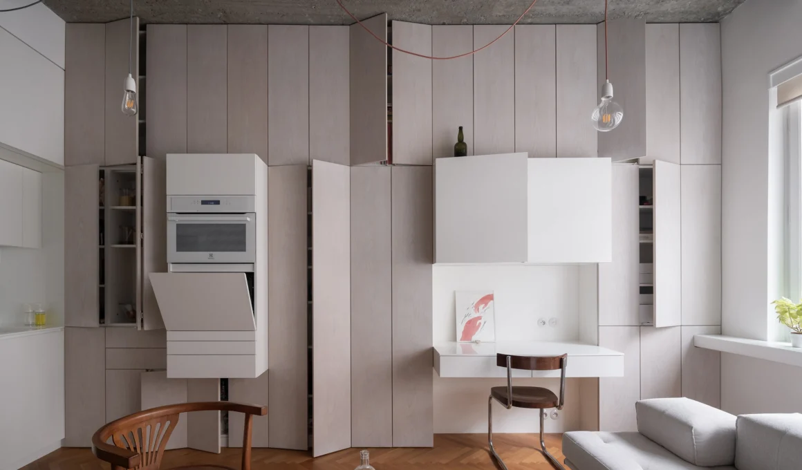 Prague functionalist apartment living room with exposed concrete ceiling and oak veneer furniture by martin cenek architecture.