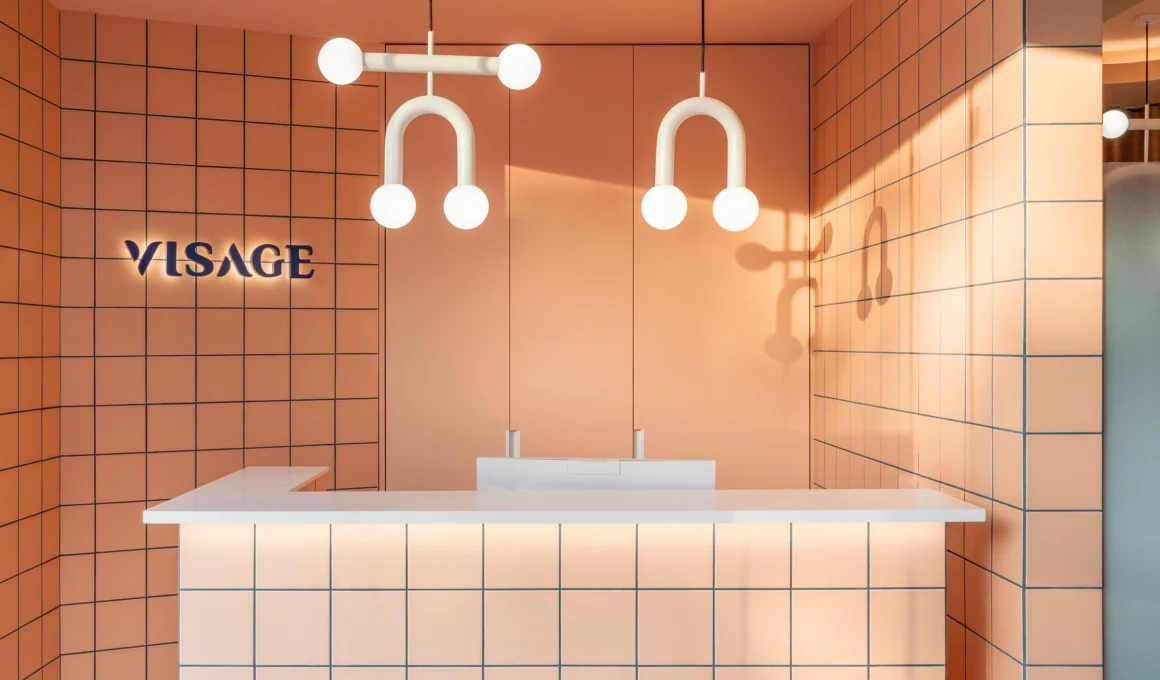 Interior design of Visage Clinic waiting area by Vitale studio, featuring terrazzo flooring, gradient glass partitions, and warm-toned furniture in a fresh, healthcare space.