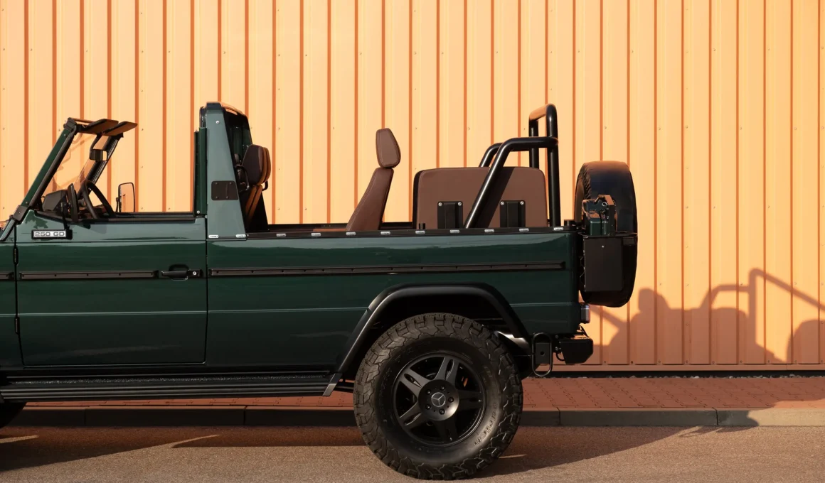 Expedition Motor Company Long Wheelbase Cabrio G-Wagen restomod in desert landscape, showing the classic military green exterior, extended chassis, and open-top convertible design.