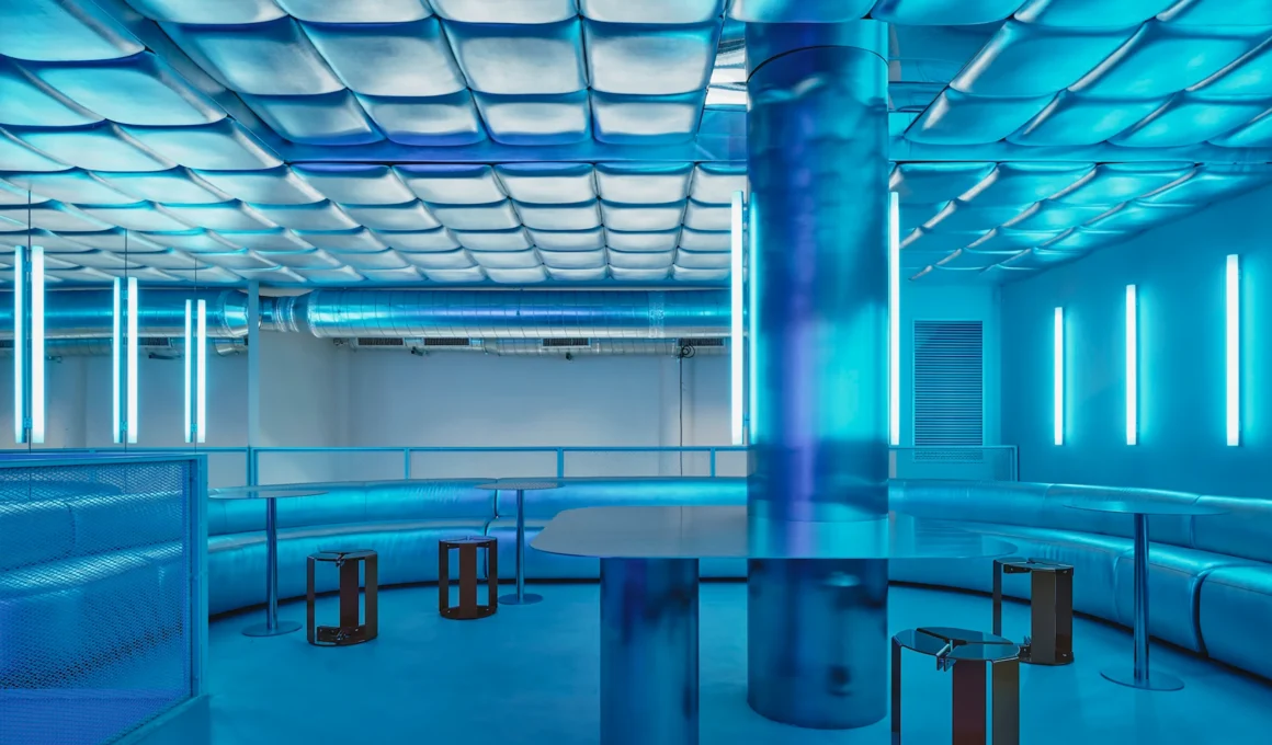 Isern Serra Relleno Barcelona interior design featuring metallic padded walls, stainless steel tables, and blue RGB lighting tint.