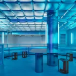 Isern Serra Relleno Barcelona interior design featuring metallic padded walls, stainless steel tables, and blue RGB lighting tint.