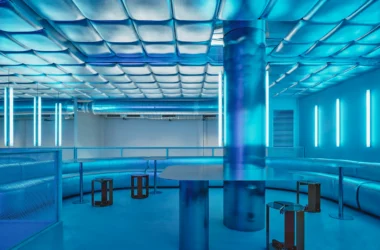 Isern Serra Relleno Barcelona interior design featuring metallic padded walls, stainless steel tables, and blue RGB lighting tint.