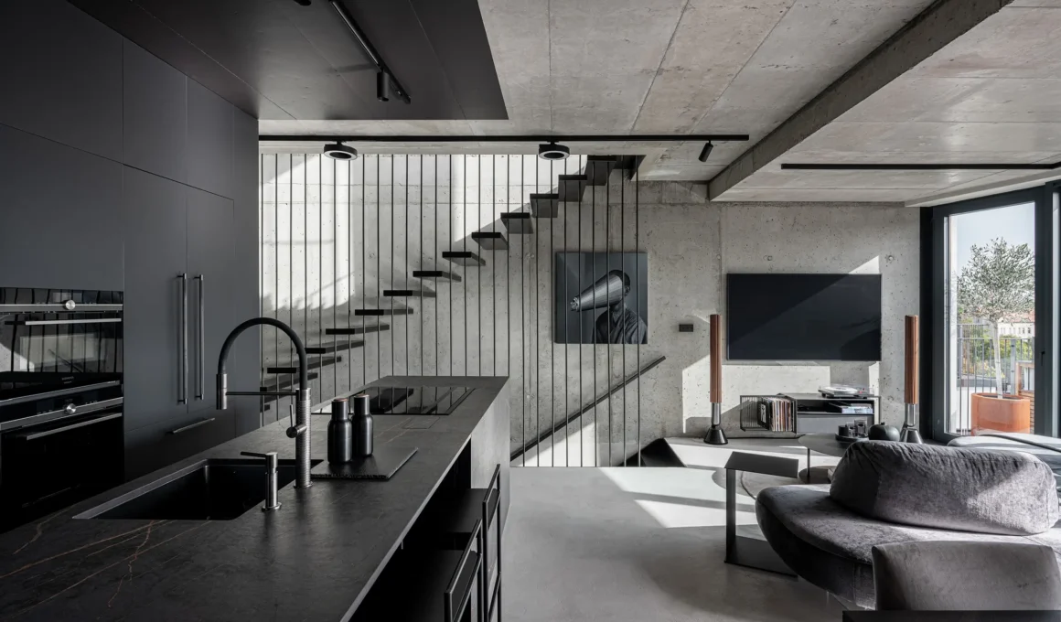 OOOOX Hrebenky apartment Prague living room kitchen view exposed concrete suspended staircase black box custom furniture