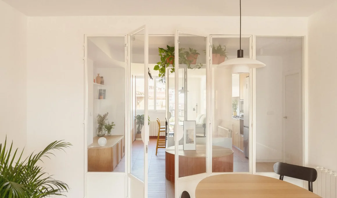Open-plan living area of Pinazo 19 Valencia apartment featuring curved ceiling and custom oak storage by La Cooperativeta Arquitectura.