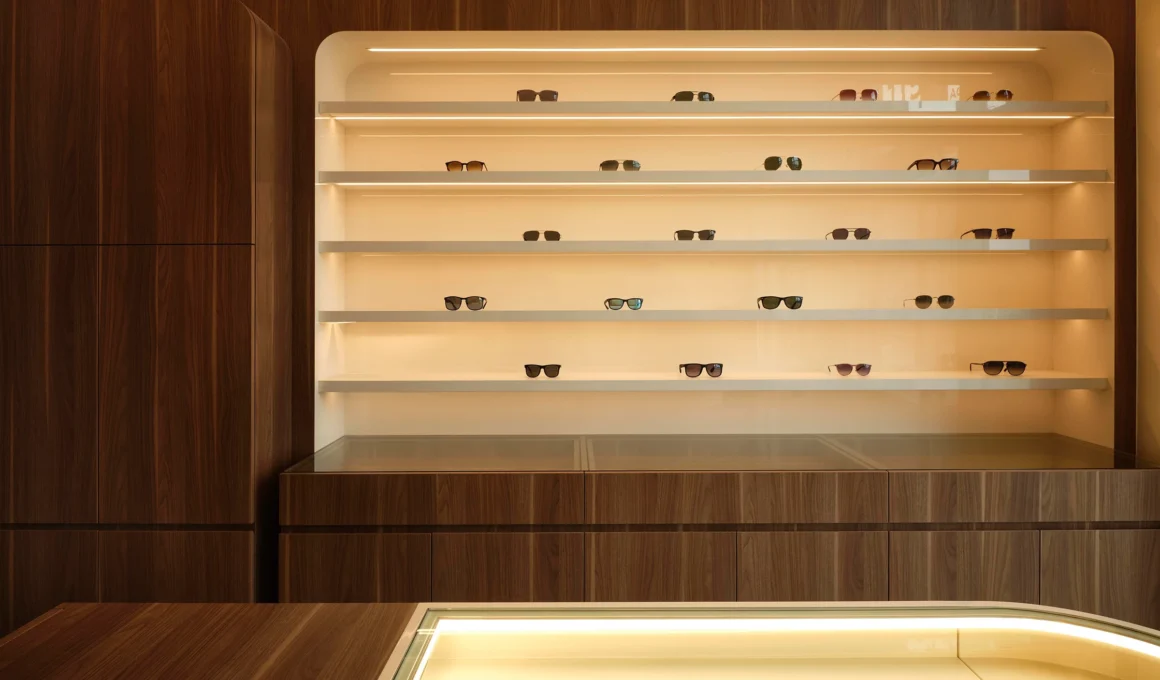 Minimalist interior design of See You Vision Care eyewear boutique in Toronto by Atelier SUN, featuring walnut wood displays and a vaulted ceiling.