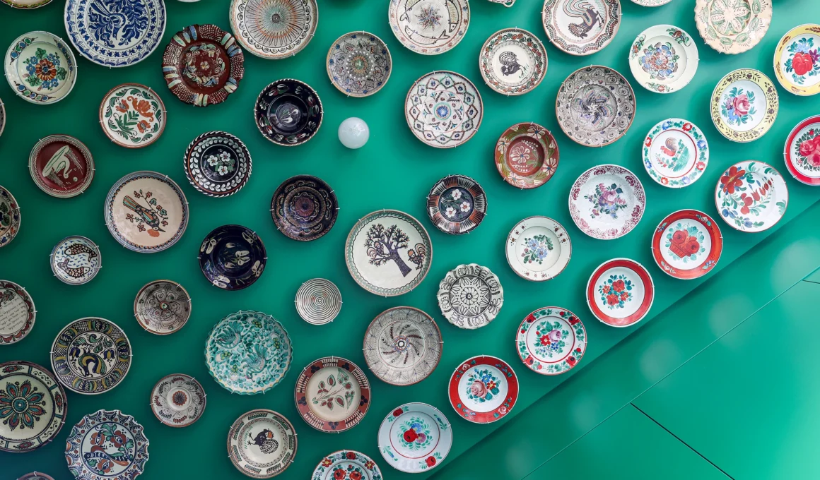 Tine Loncin designed deep green kitchen in Brussels apartment, blending Romanian folk art with contemporary design.