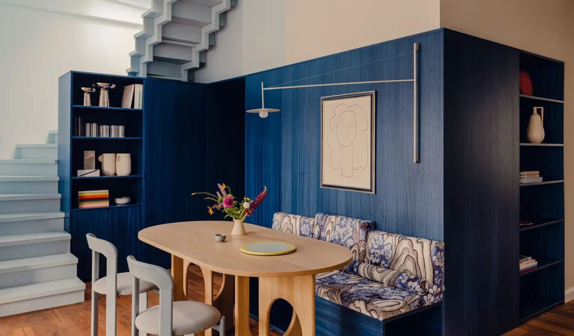 Bruzkus Greenberg Blue Box apartment interior featuring a central dark blue millwork volume, butter-yellow sofa, and sky-blue ceiling in the 75 sqm Berlin rooftop design.