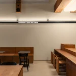 Daikan Ramen Dubai interior by KIDZ Studio featuring large-scale Japanese joinery using plywood and stainless steel.