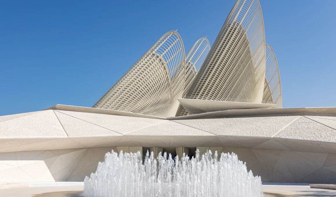 Foster + Partners Zayed National Museum Abu Dhabi entrance with five sculptural falcon wings rising from the sand-colored sustainable architecture mound.