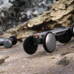 Hyundai MobED Mobile Eccentric Droid robot platform autonomously carrying a golf bag on a sunny, green golf course.