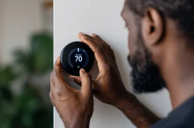 Man adjusting smart thermostat touch screen controlling high-efficiency HVAC for precision climate control in a modern, luxury living room.