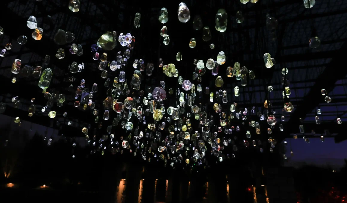 Close-up of James Tapscott's The Beholder light installation, showing glowing, magnified flora samples encased in clear resin bulbs.