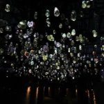 Close-up of James Tapscott's The Beholder light installation, showing glowing, magnified flora samples encased in clear resin bulbs.