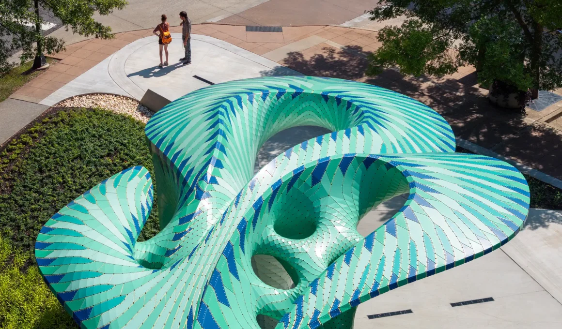 Marc Fornes THEVERYMANY Pier 865 public art installation, featuring a turquoise and green perforated aluminium canopy resting on a concrete pier in Knoxville, Tennessee's park.