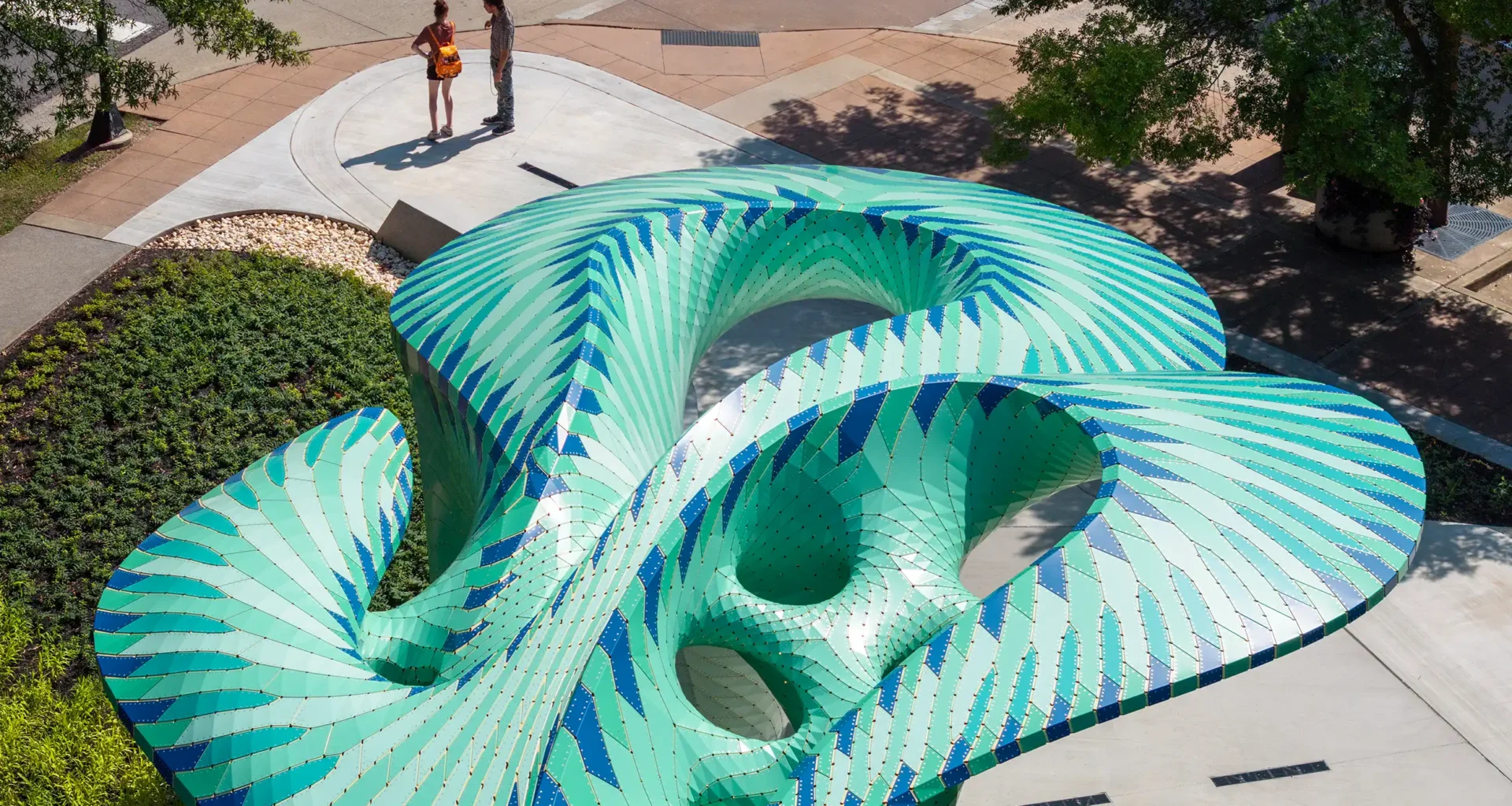 Marc Fornes THEVERYMANY Pier 865 public art installation, featuring a turquoise and green perforated aluminium canopy resting on a concrete pier in Knoxville, Tennessee's park.