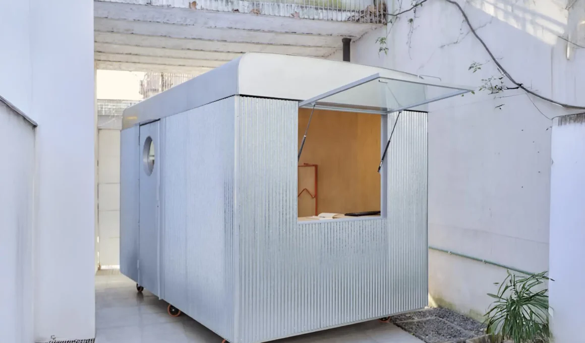 Exterior view of Morsa Taller's 7 sqm mobile office, a prefabricated corrugated metal and wheeled structure parked outdoors.