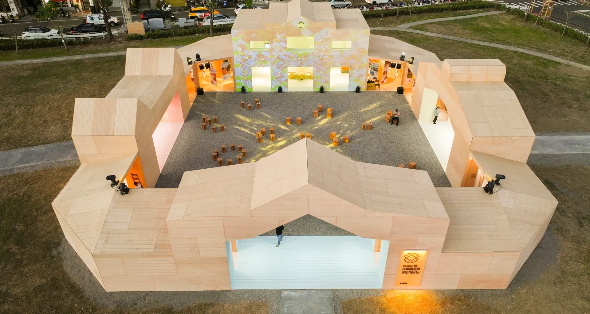 Aerial view of MVRDV's Wooden Wonders timber pavilion in Chiayi, featuring a central courtyard and geometric rooflines inspired by local cultural heritage.