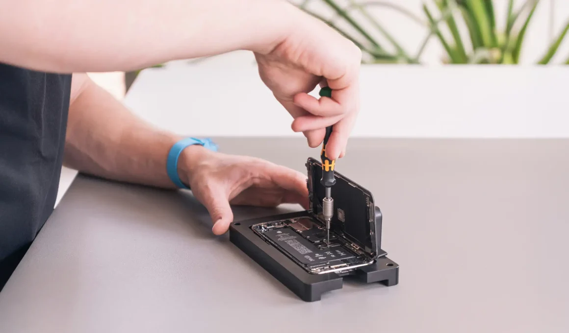 iPhone repair technician fixing phone screen and internal components, illustrating common problems like cracked screens or battery replacement.