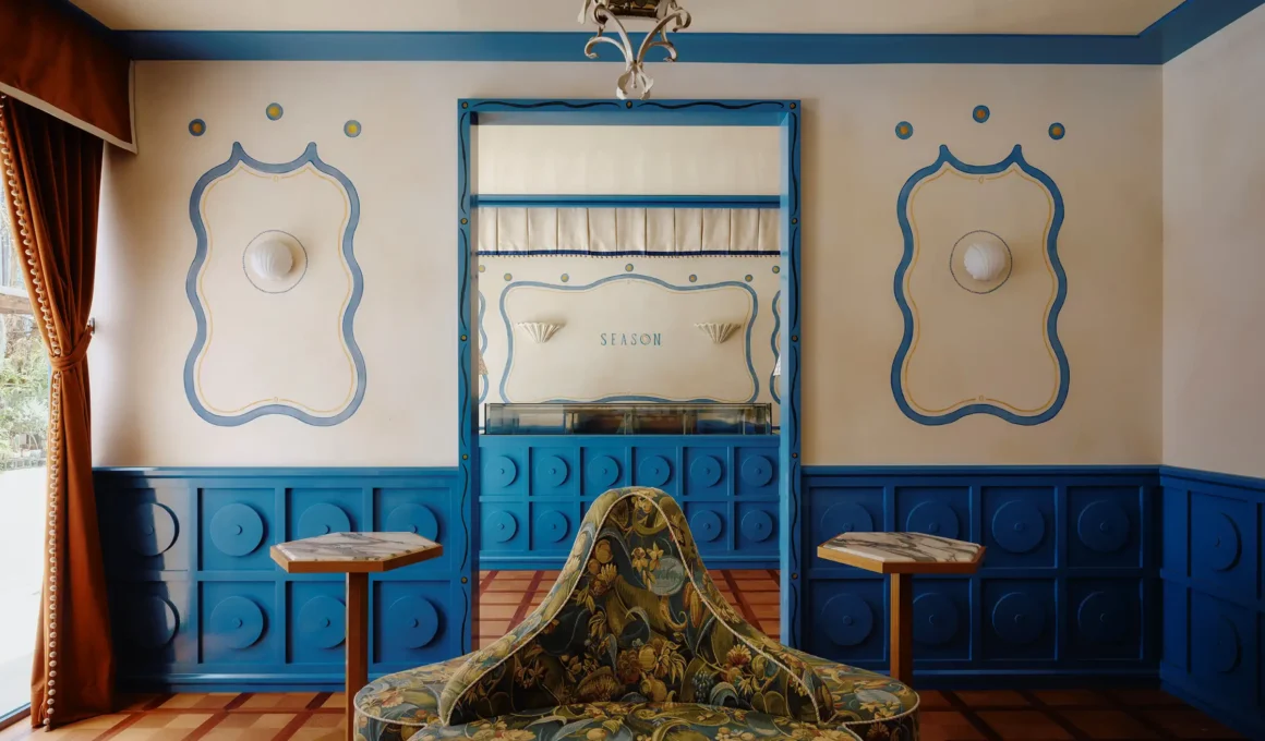 Floral upholstered armchair set against blue and ivory wainscoting with "SEASON" branding at Season Patisserie in Taipei by ECRU STUDIO.