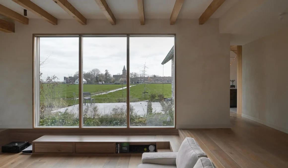 Unknown Architects Villa Voorwerf interior and exterior split view showing living room, fireplace, exposed timber beams, and dual timber-clad gable roof volumes in Zunderdorp, Netherlands.