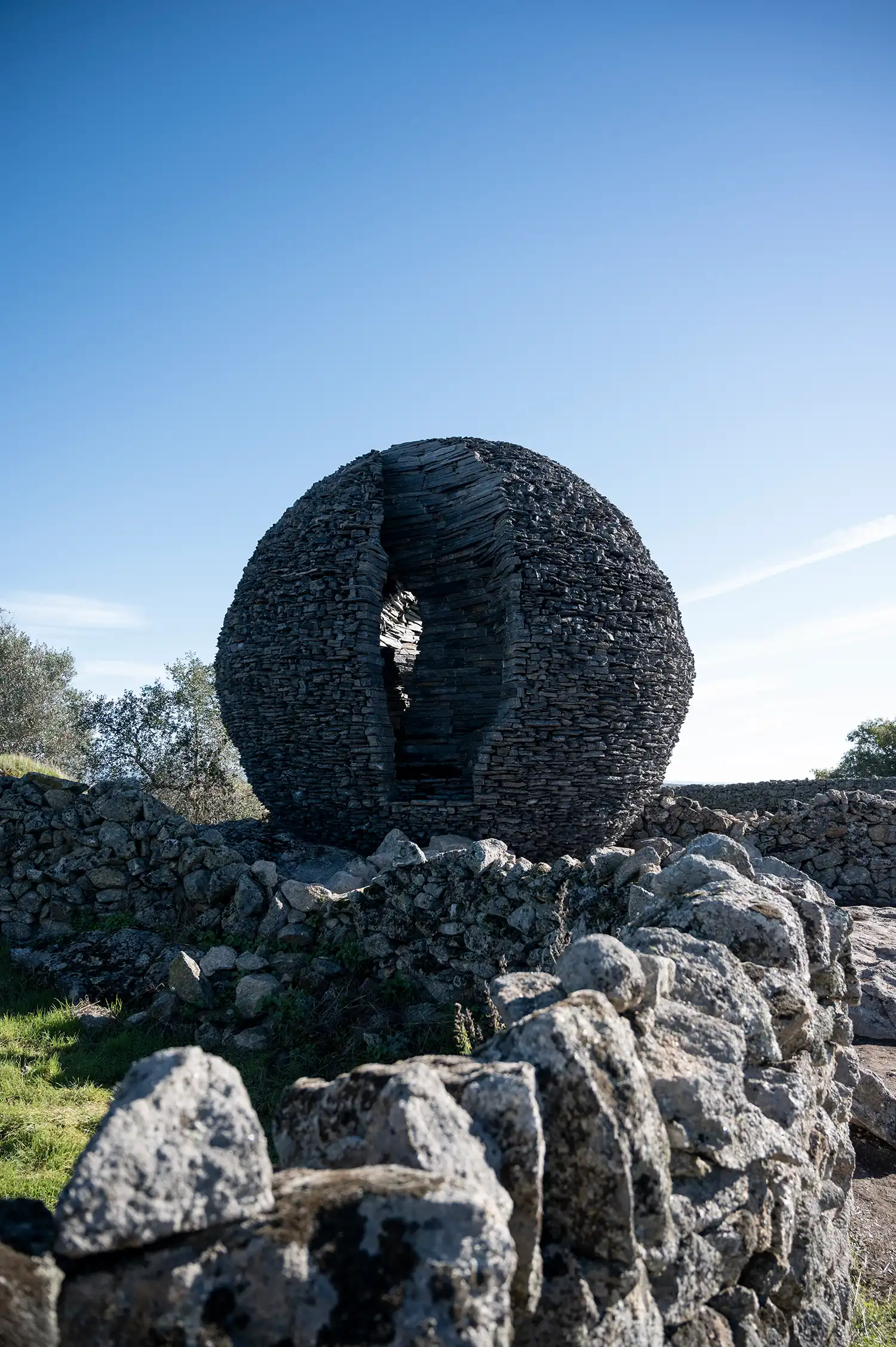 Interior view of a hollow stone sphere showing the layered schist texture and a narrow vertical opening.