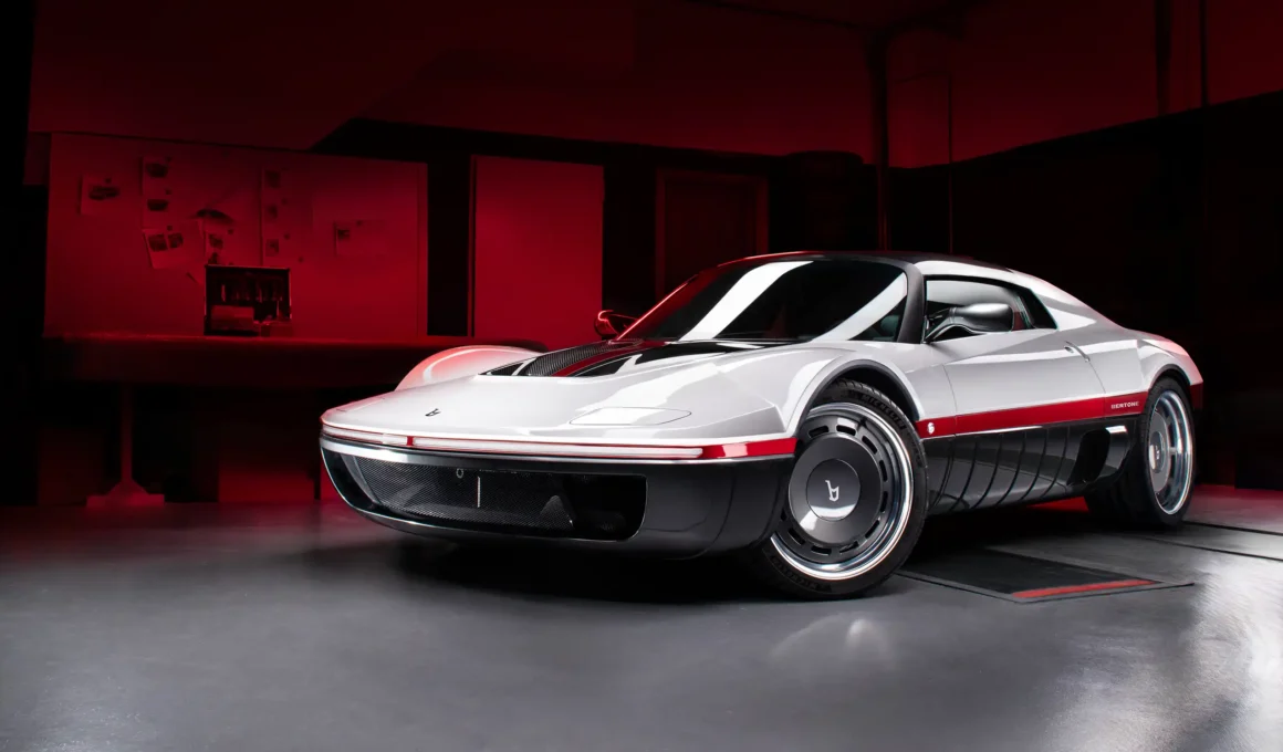 Front three-quarter view of the white and black Bertone Runabout in a red-lit studio.