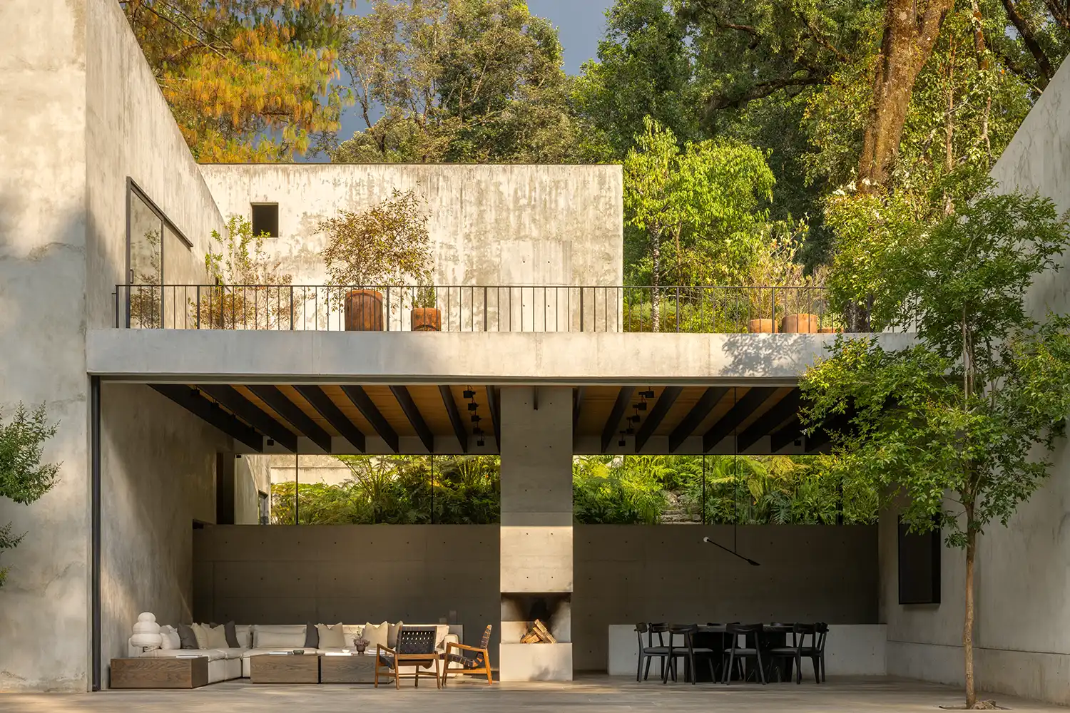A wide view of the open-air living and dining pavilion sheltered by a concrete slab.