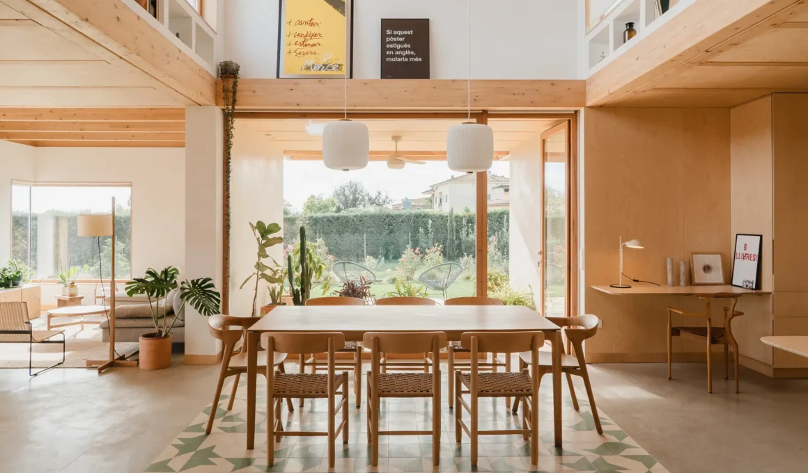 Open-plan dining room in Casa al Pradet with geometric green tiles and timber beams.